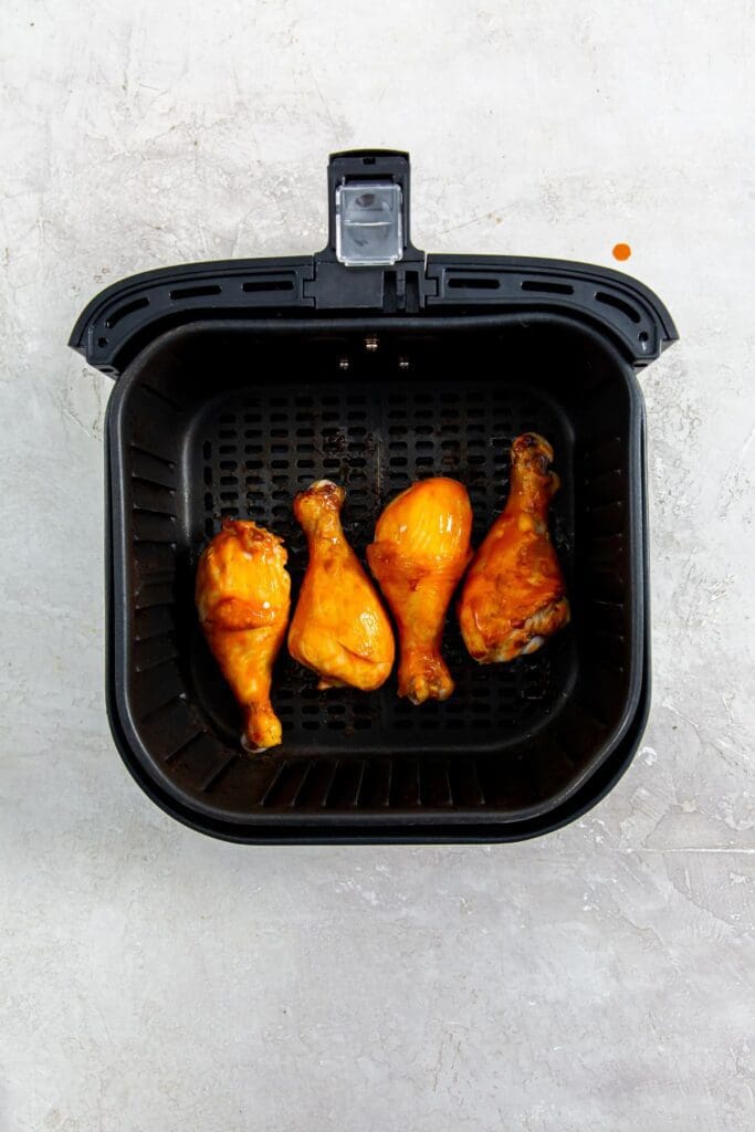 black air fryer basket with chicken inside