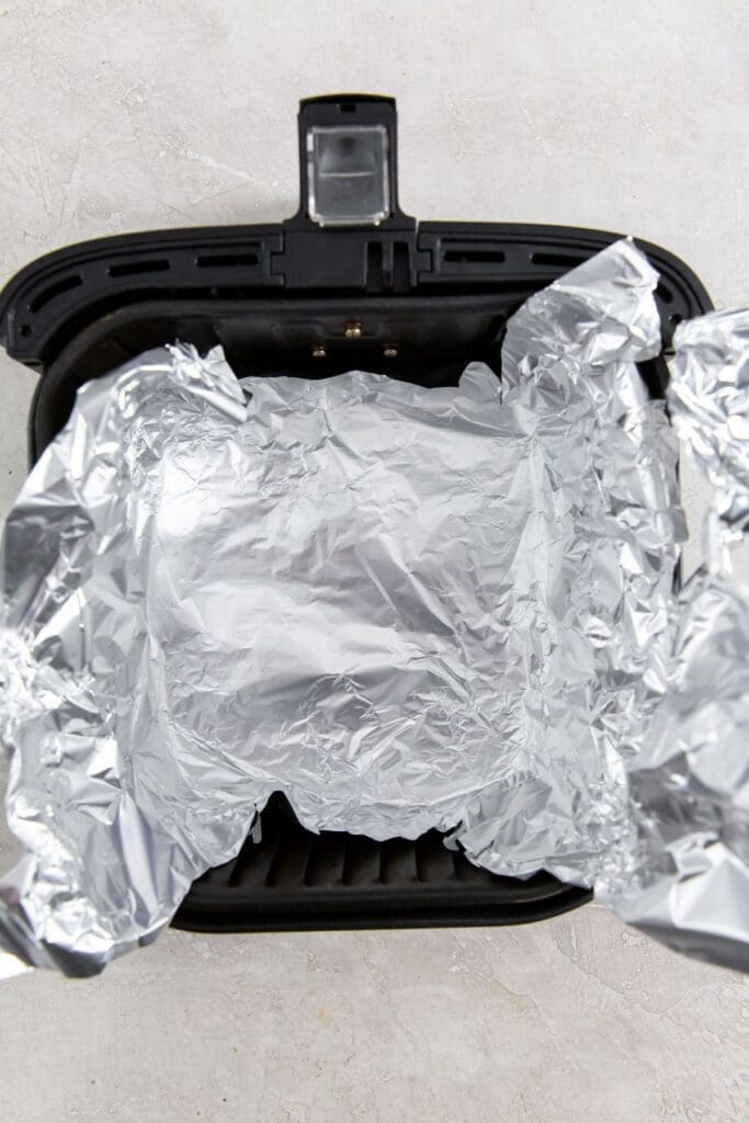 black air fryer basket with aluminum foil