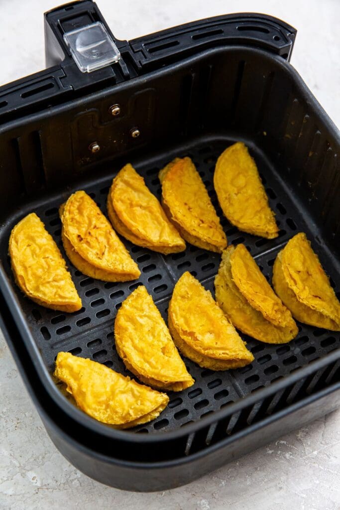 black air fryer basket with cooked tacos inside