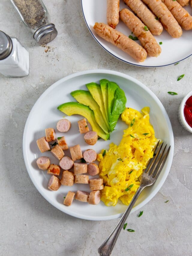 plate with sausage, eggs, and avocado slices.