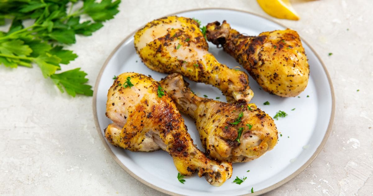 Air Fryer Lemon Pepper Chicken Legs on a white plate with parsley.