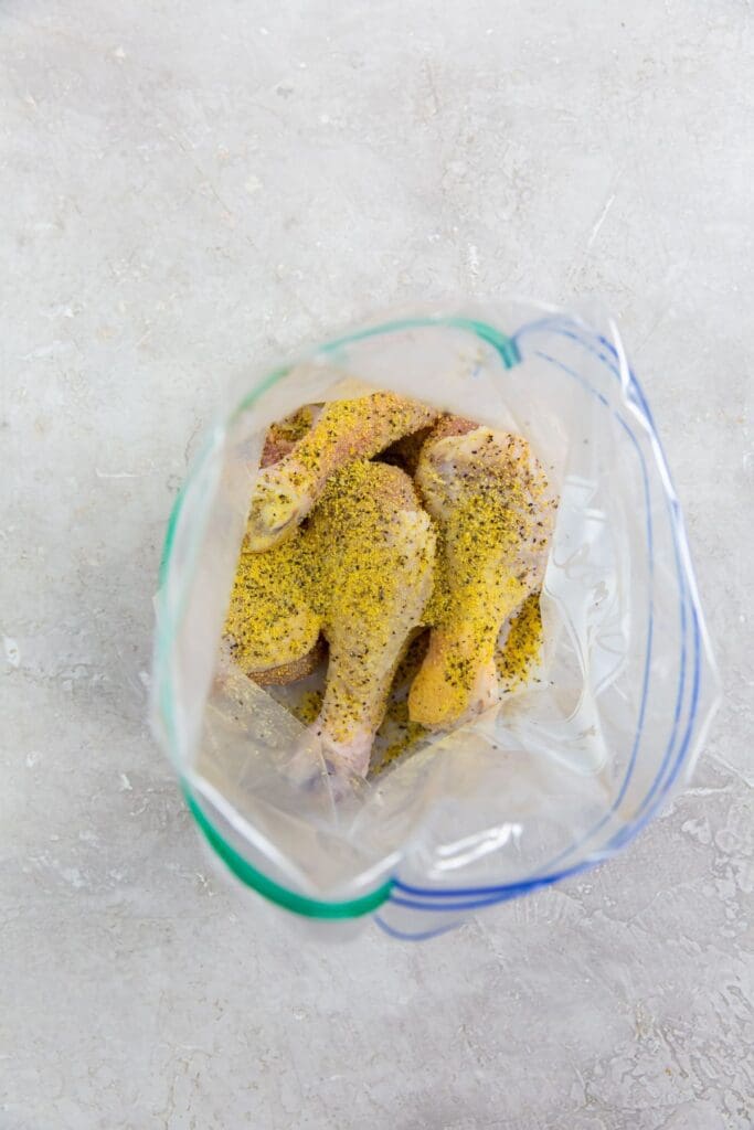 ziplock bag with raw chicken and seasoning inside