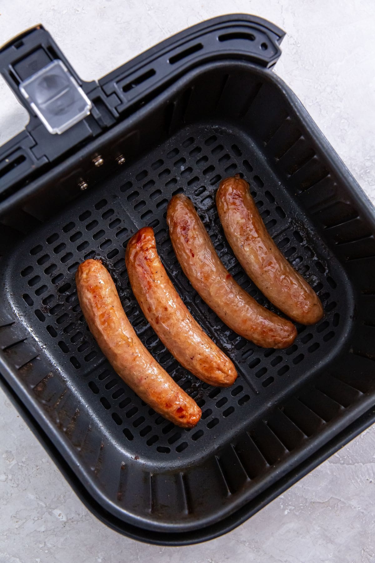 black air fryer basket with cooked chicken inside