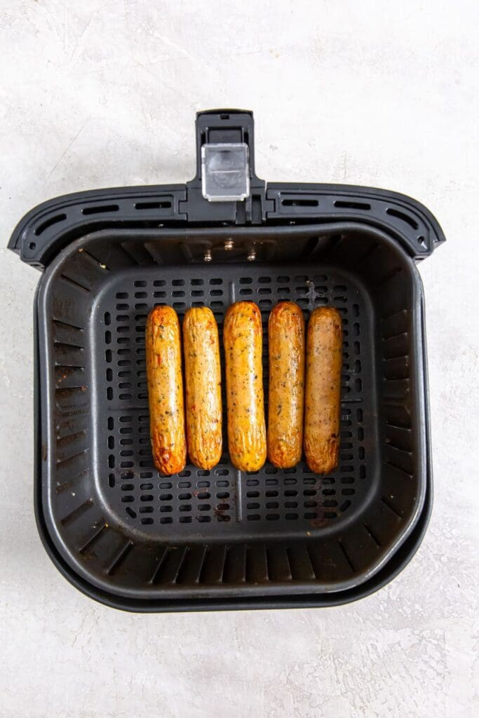 black air fryer basket with cooked chicken inside