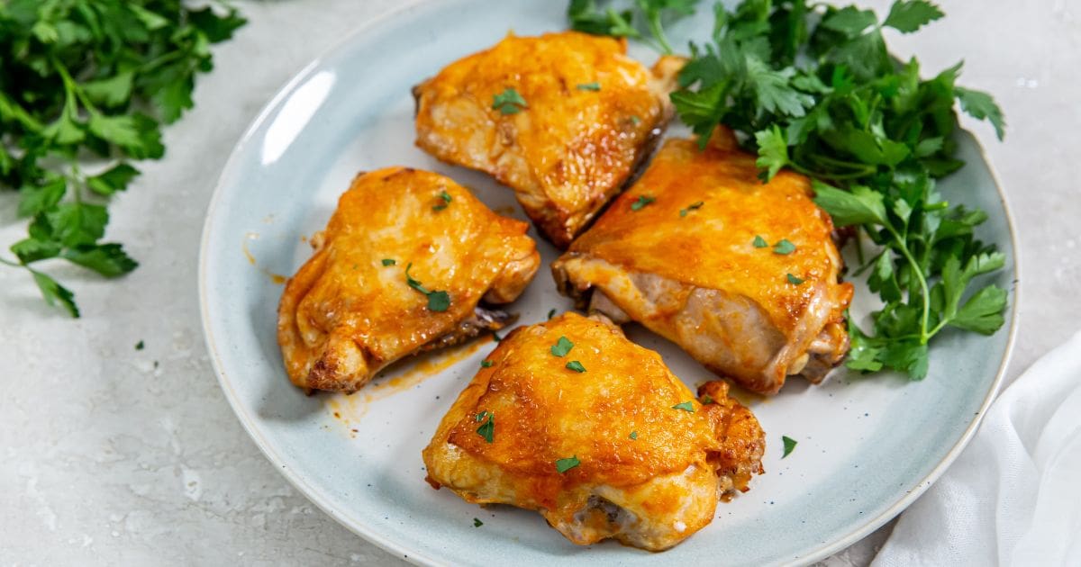 Air Fryer Buffalo Chicken Thighs on a light blue plate with parsley.