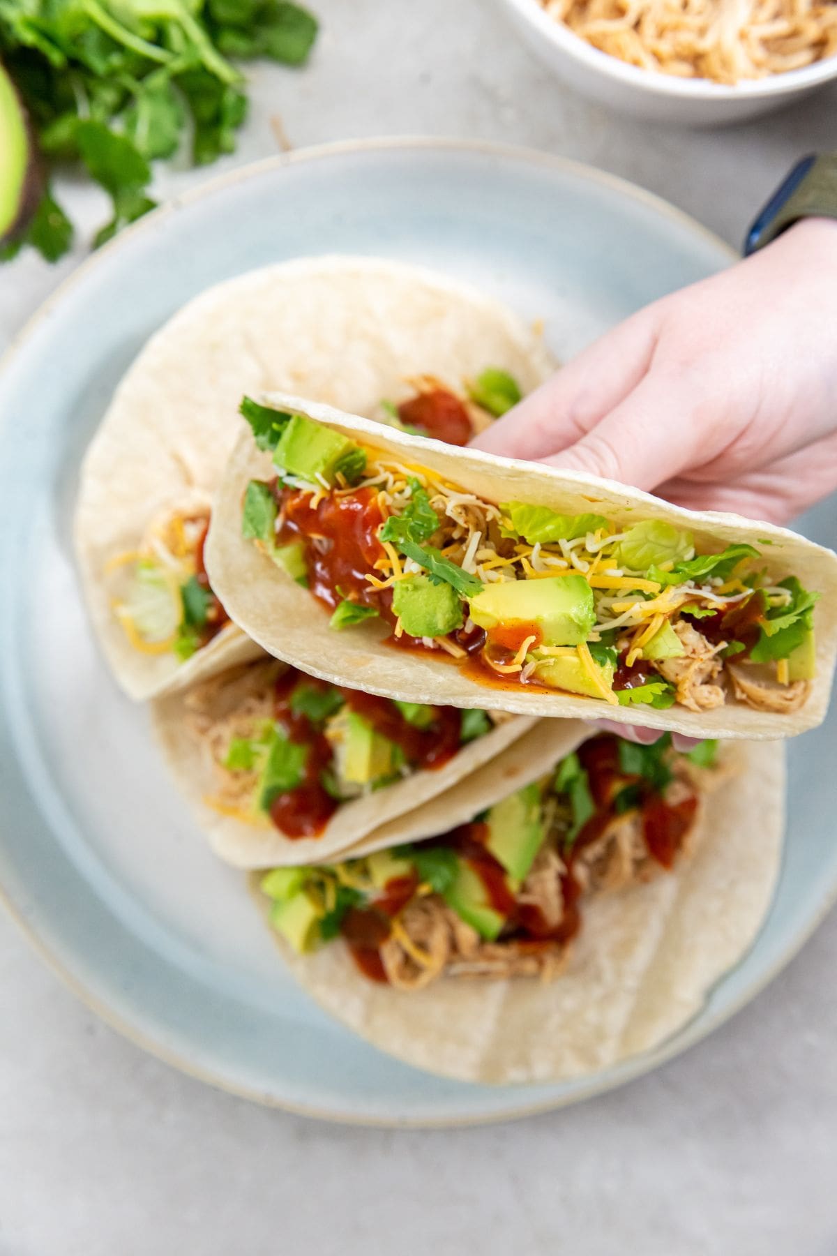 tacos on a plate and person holding one