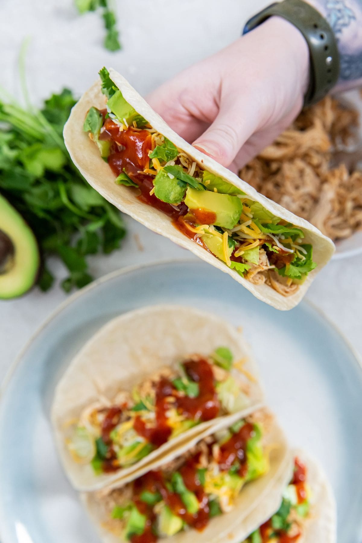 tacos on a plate and person holding one