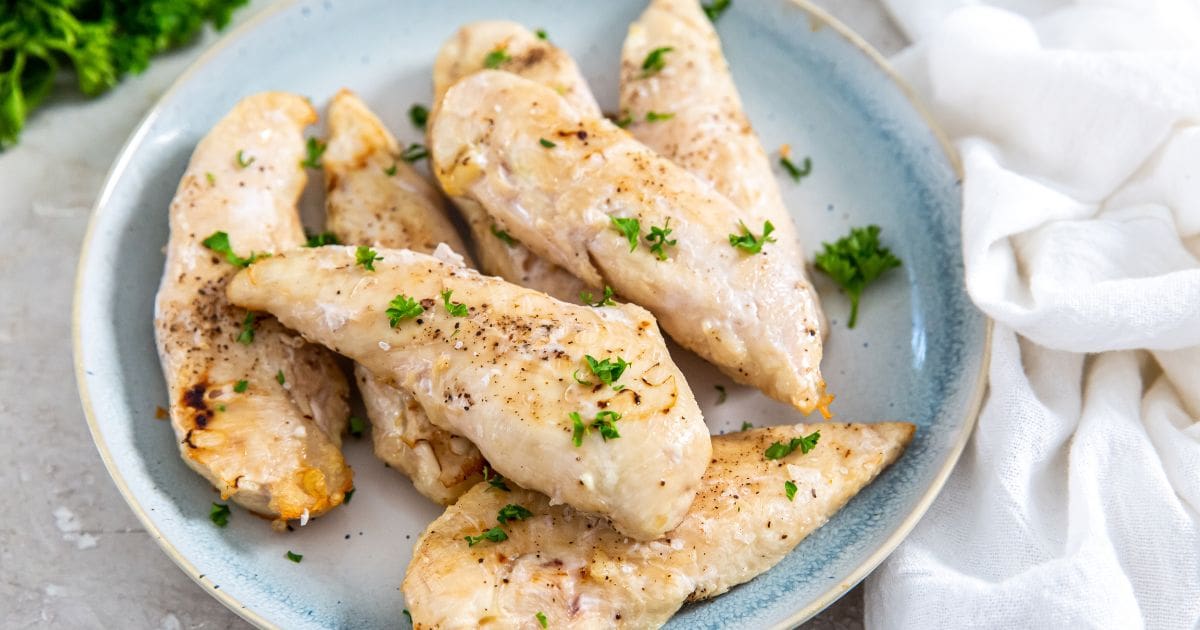 Frozen Chicken Tenders in Air Fryer on a light blue plate with parsley.