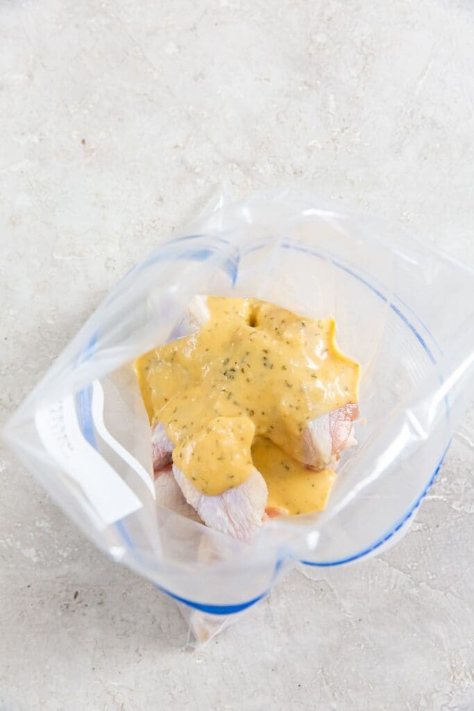 ziplock bag with sauce poured on top of chicken