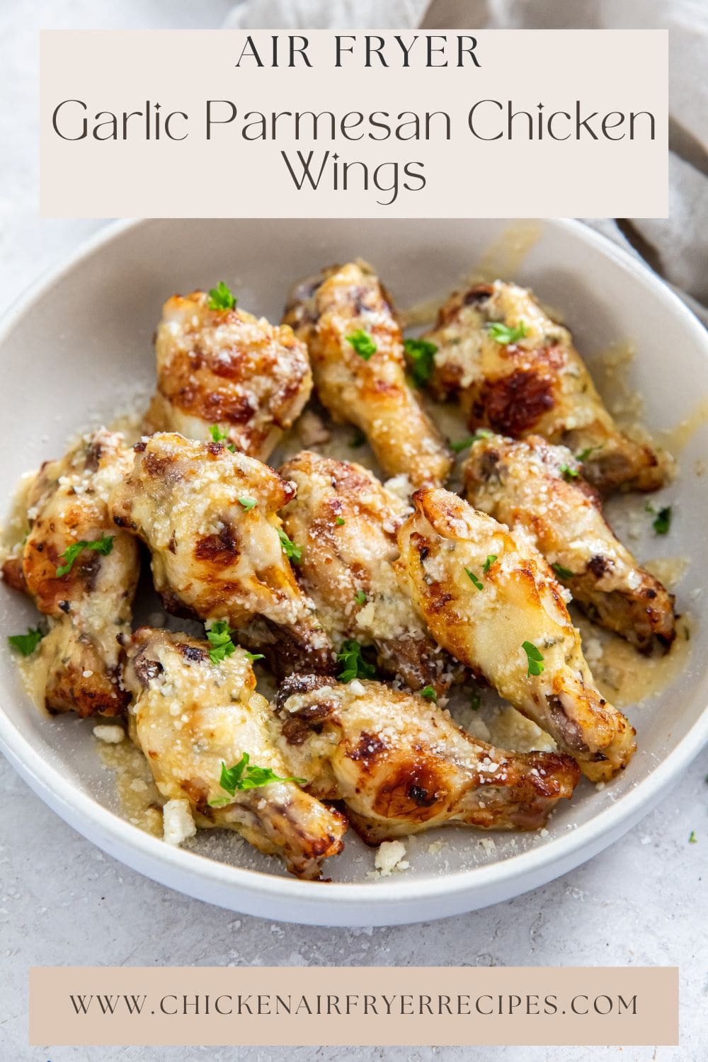 garlic Parmesan wings in white bowl. gray towel next to it.