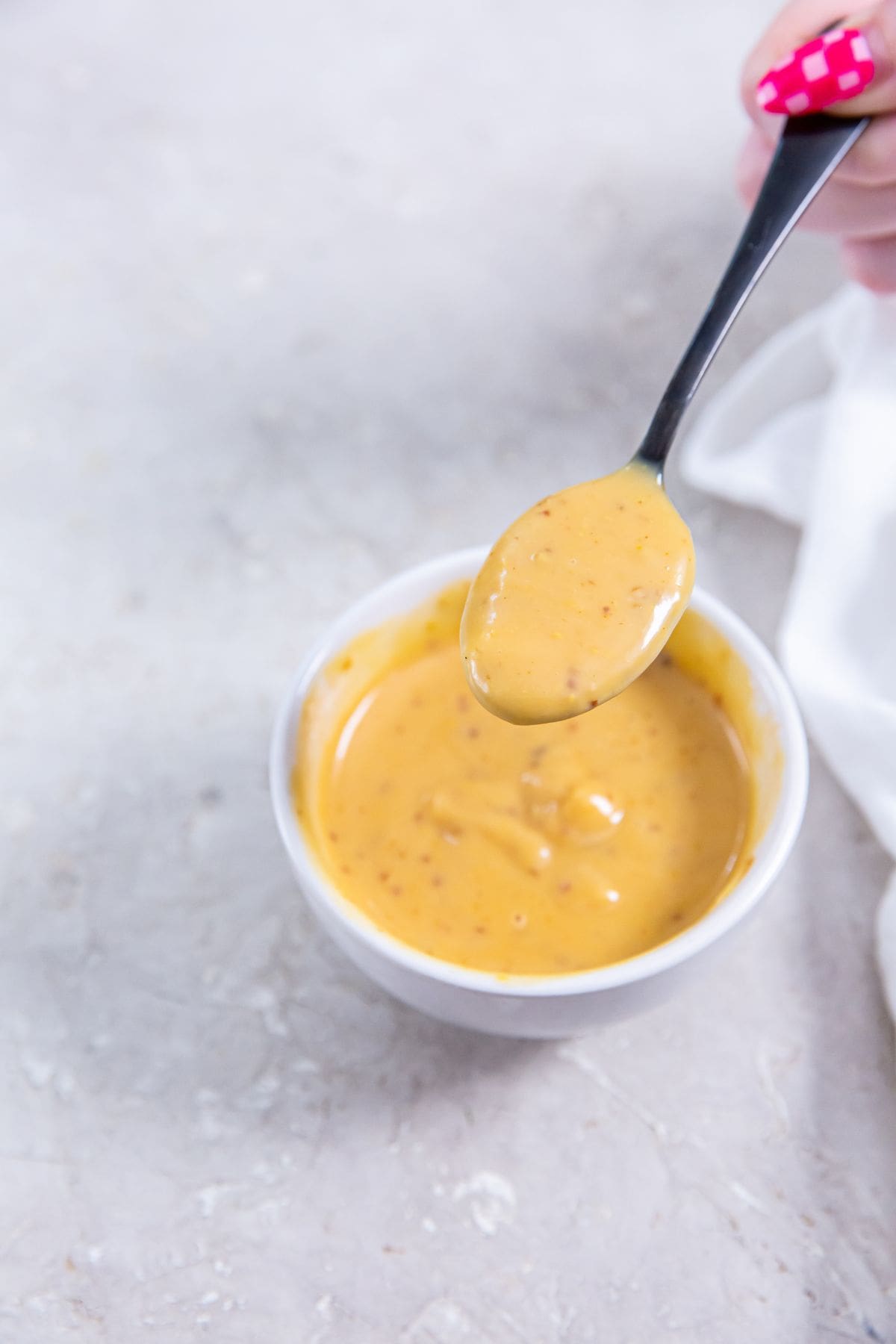 white bowl with copycat chick-fi-a sauce inside. spoon above bowl