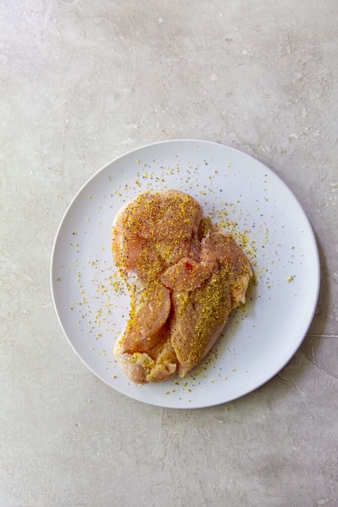 A chicken breast cooked in an air fryer, served on a white plate.