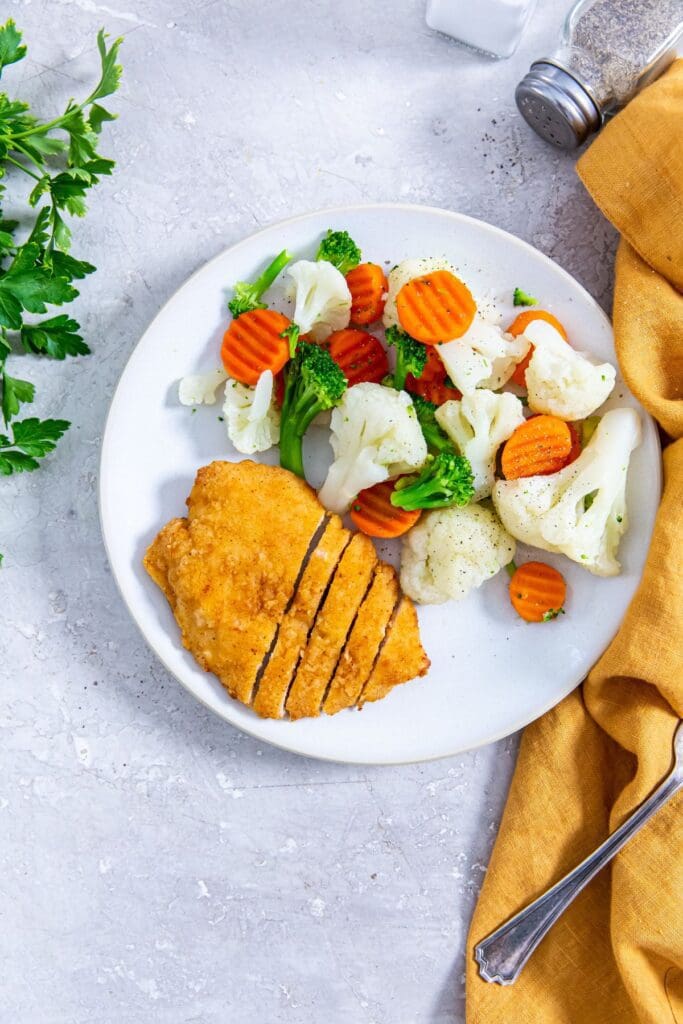 Aldis Red Bag Chicken served with vegetables on a plate.