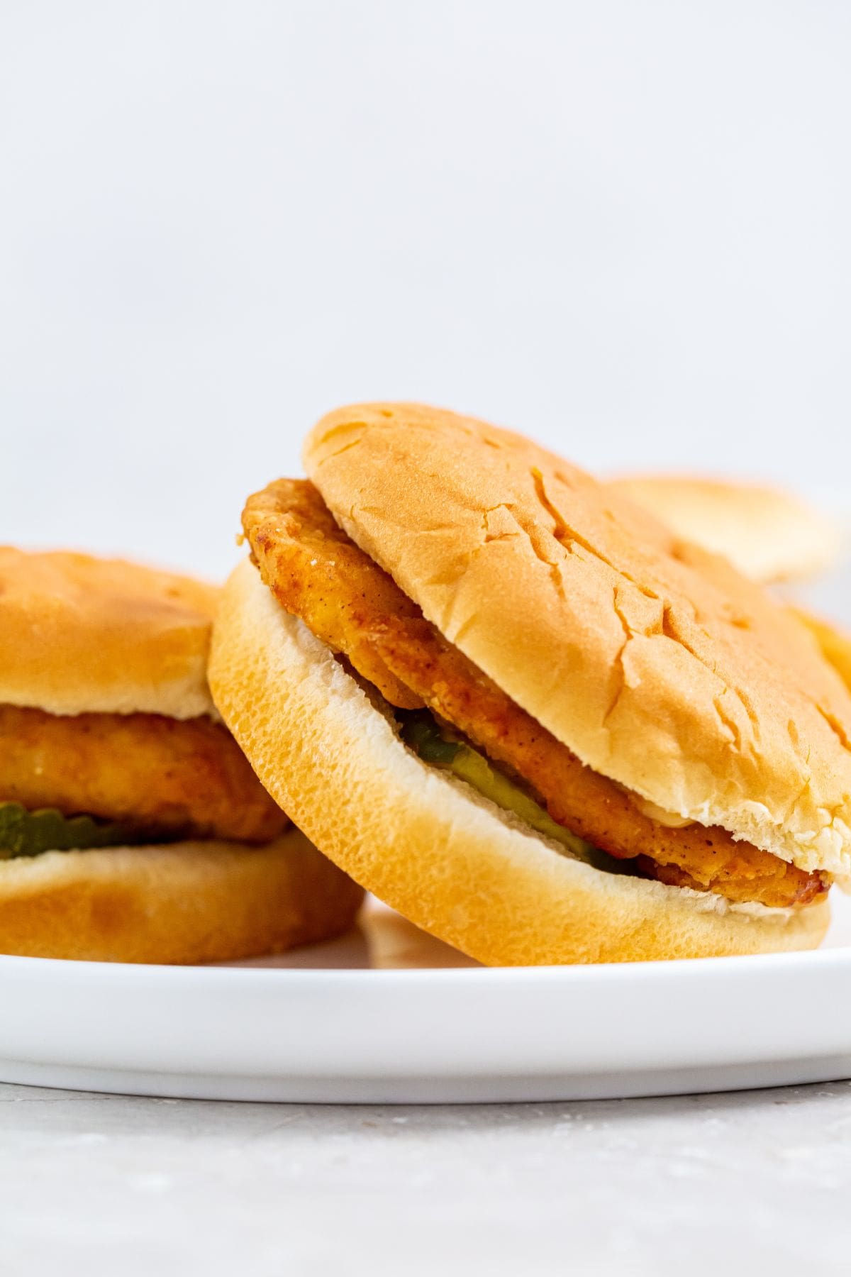 chicken sandwich on a white plate.