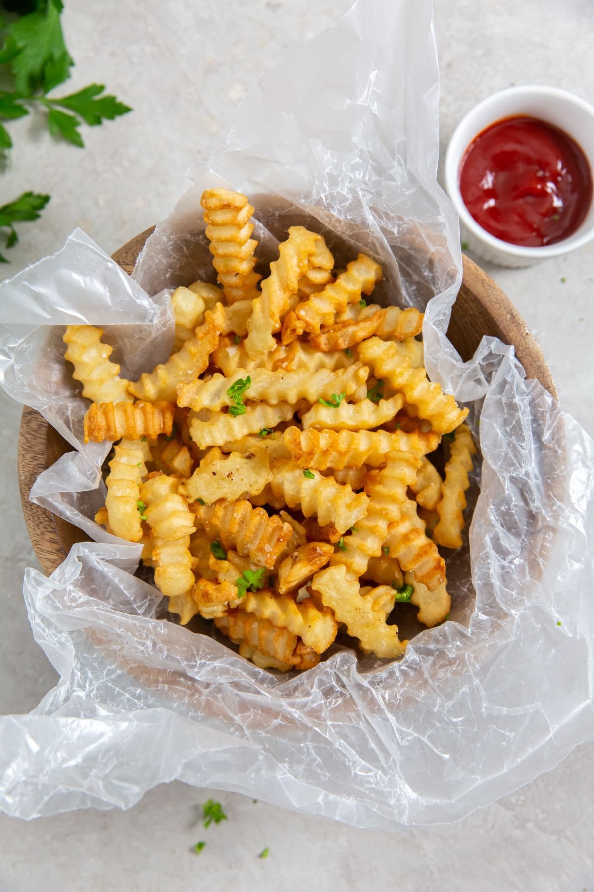 French fries cooked in an air fryer, served in a bowl with ketchup.