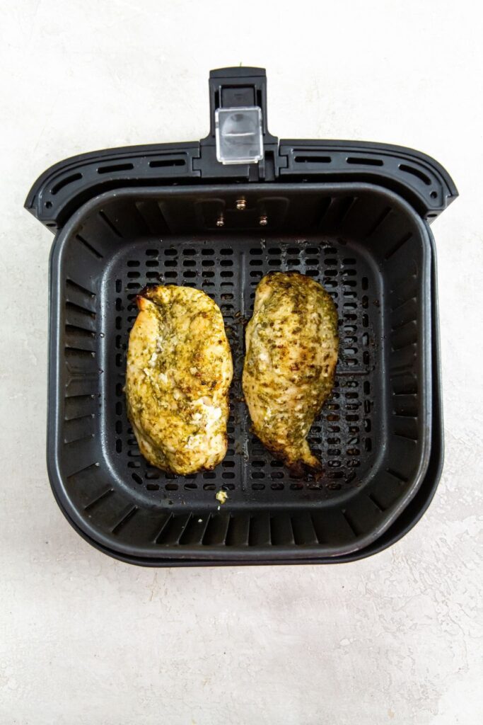 Air Fryer Pesto Chicken Breast black air fryer basket with chicken inside