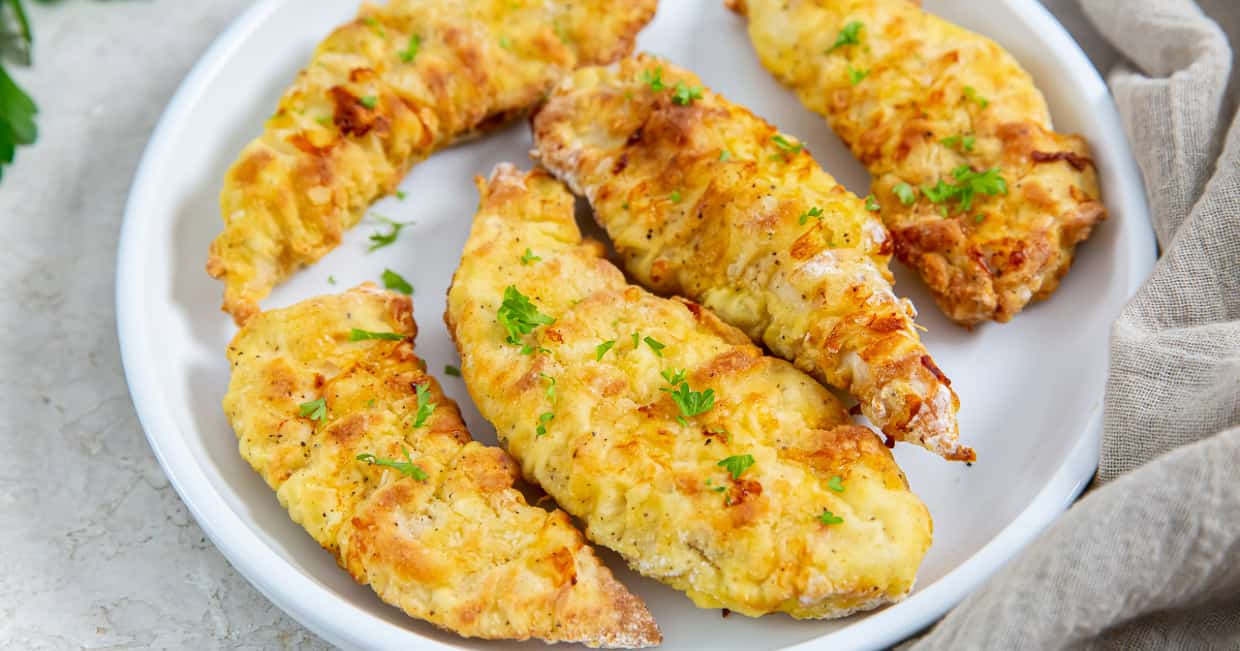 Easy Air Fryer Chicken Tenders with Flour on a white plate with parsley