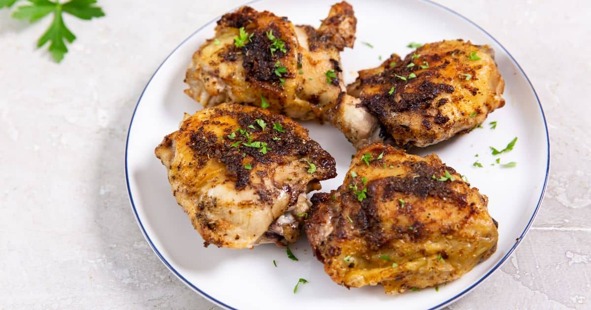 Easy Air Fryer Blackened Chicken Thighs on a white plate with parsley.