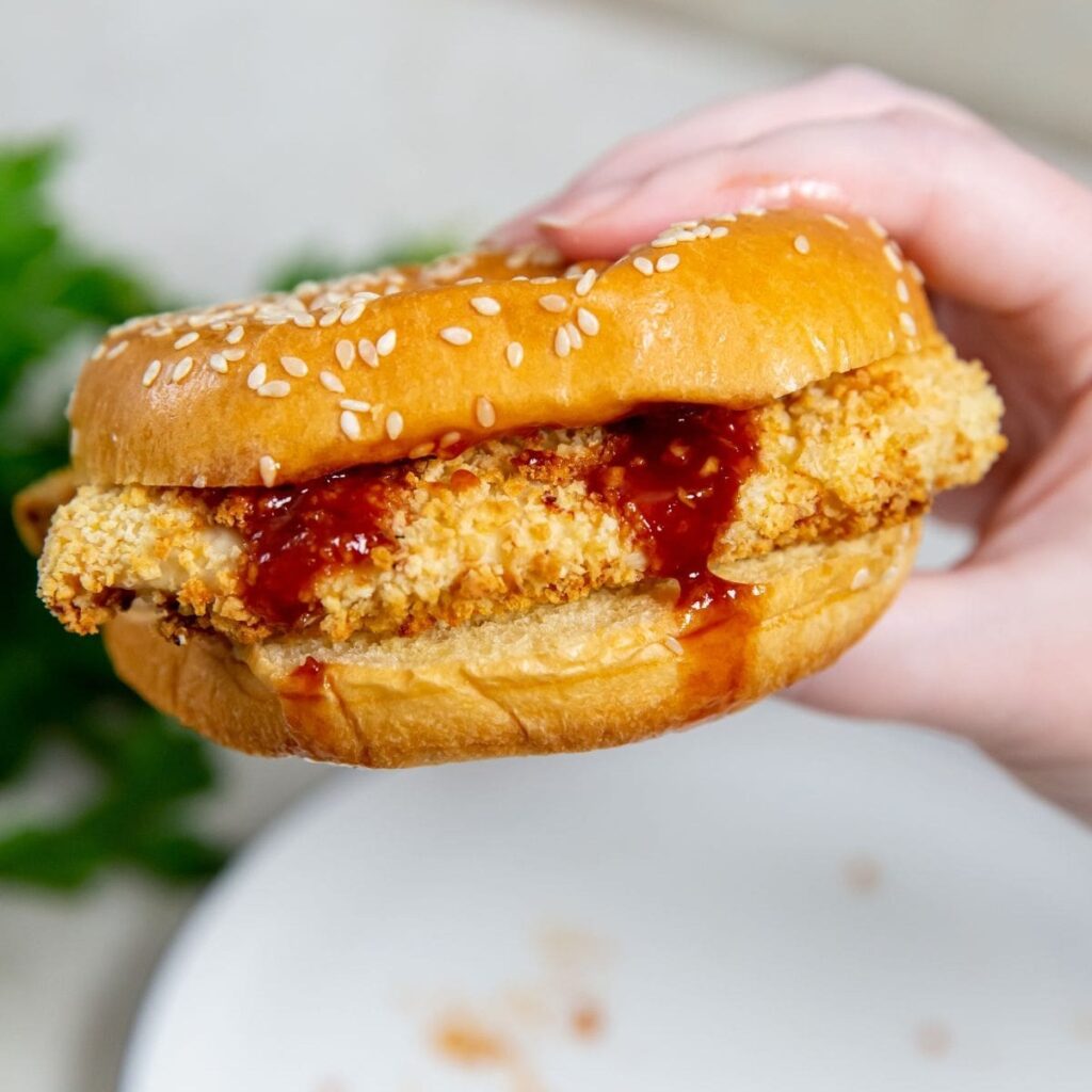 Tasty Chicken Air Fryer Recipes Close Up of a Katsu Chicken Sandwich in a Person's Hand