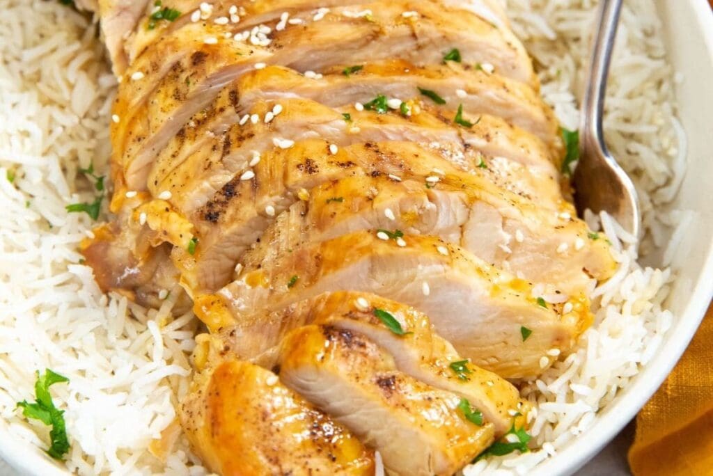 Air Fryer Recipes That’ll Make You Forget Your Stove Close Up of Sliced Chicken Breast on Rice in a White Bowl