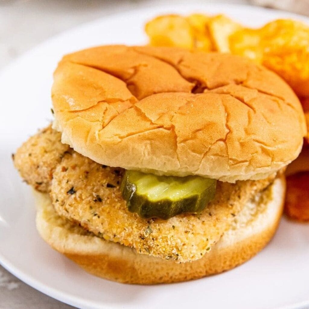 Chicken Air Fryer Recipes to Convert the Fussiest Foodies Close Up of a Chicken Sandwich with Pickles and BBQ Chips