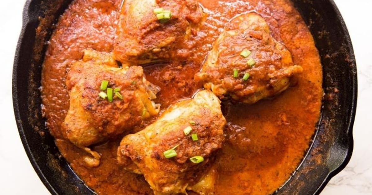 These 20 Chicken Recipes Are Everything You Need Right Now Close Up of a Cast Iron Skillet with Cast Iron Chicken Thighs in Creamy Tomato Sauce