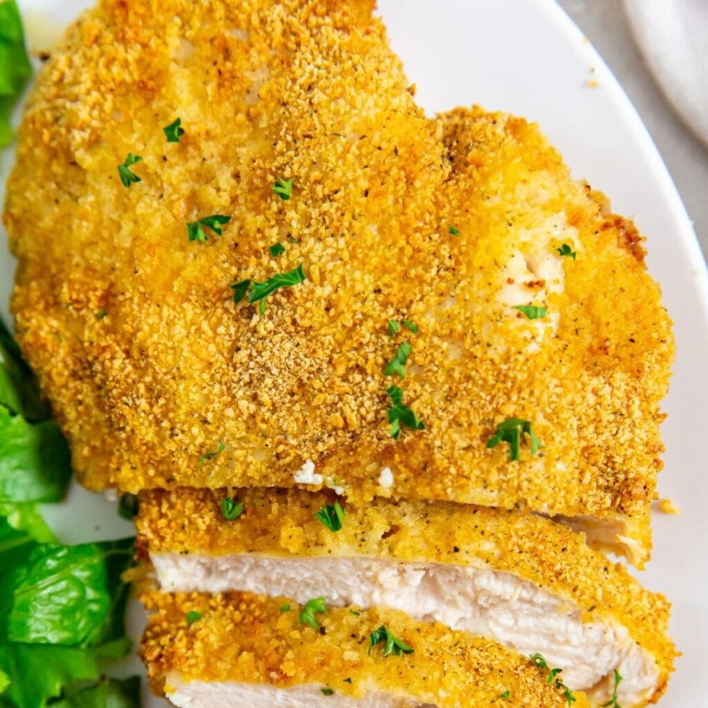 Chicken Recipes That Are Everything Close Up of Shake and Bake Chicken on a Plate with Salad