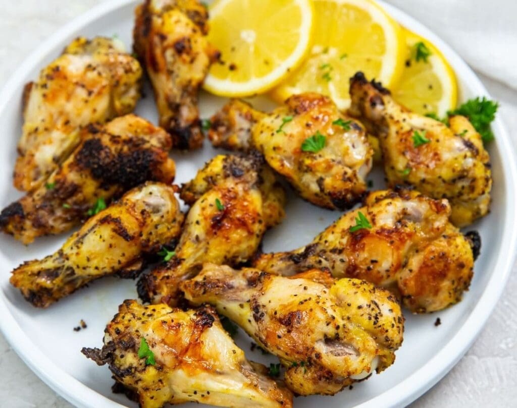 Air Fryer Dinners Close Up of Lemon Pepper Wings on a Plate with Lemon Slices