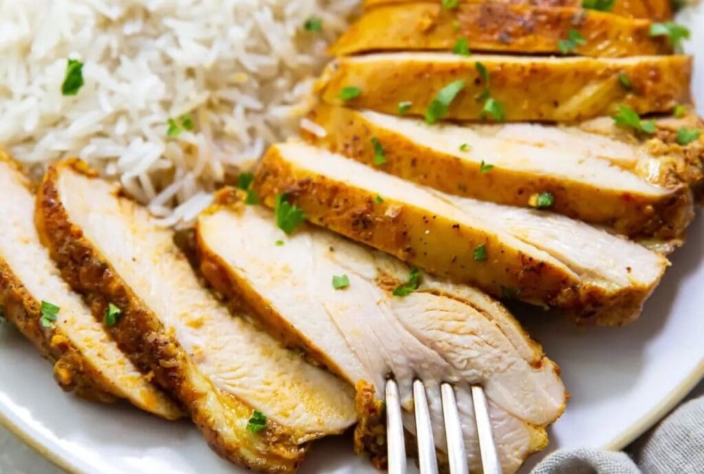 Must-Try Chicken Air Fryer Recipes Close Up of Sliced Chicken Breast on Rice with a Fork