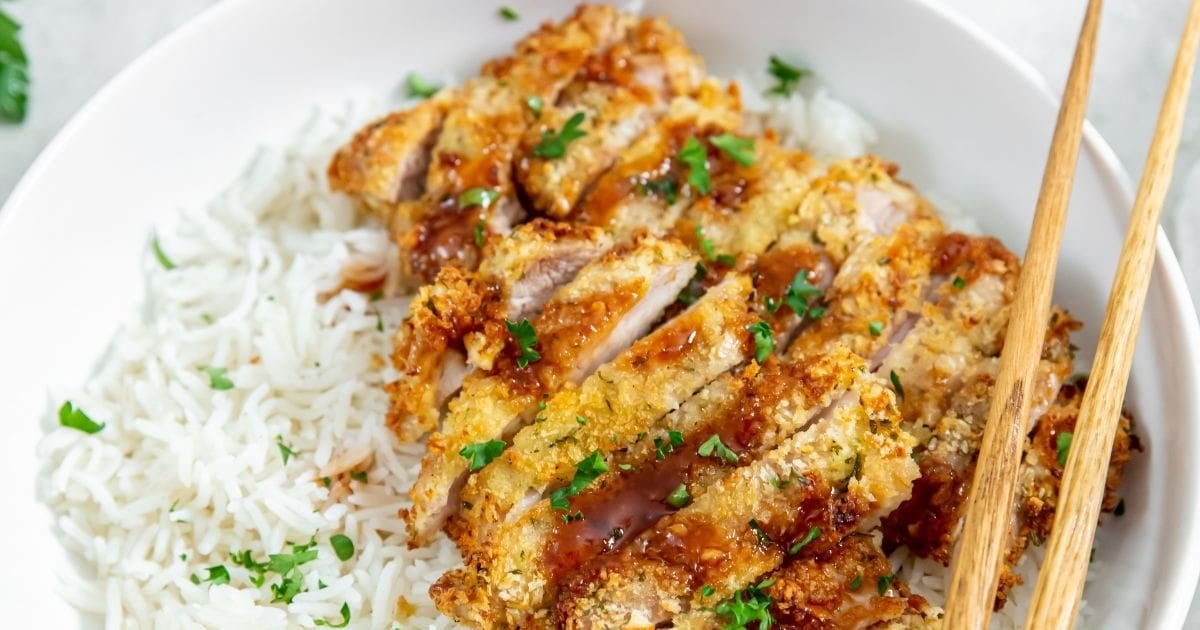 10 Air Fryer Recipes Close Up of Sliced Katsu Chicken on White Rice in a White Bowl Topped with Chopsticks