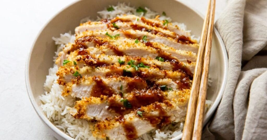 18 Fast & Flavorful Chicken Air Fryer Recipes Close Up of a Bowl of Chicken Katsu with White Rice and Chopsticks