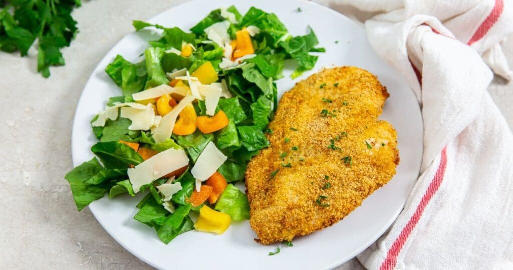 18 Fast & Flavorful Chicken Air Fryer Recipes Shake and Bake Chicken Cutlet with Salad on a White Plate