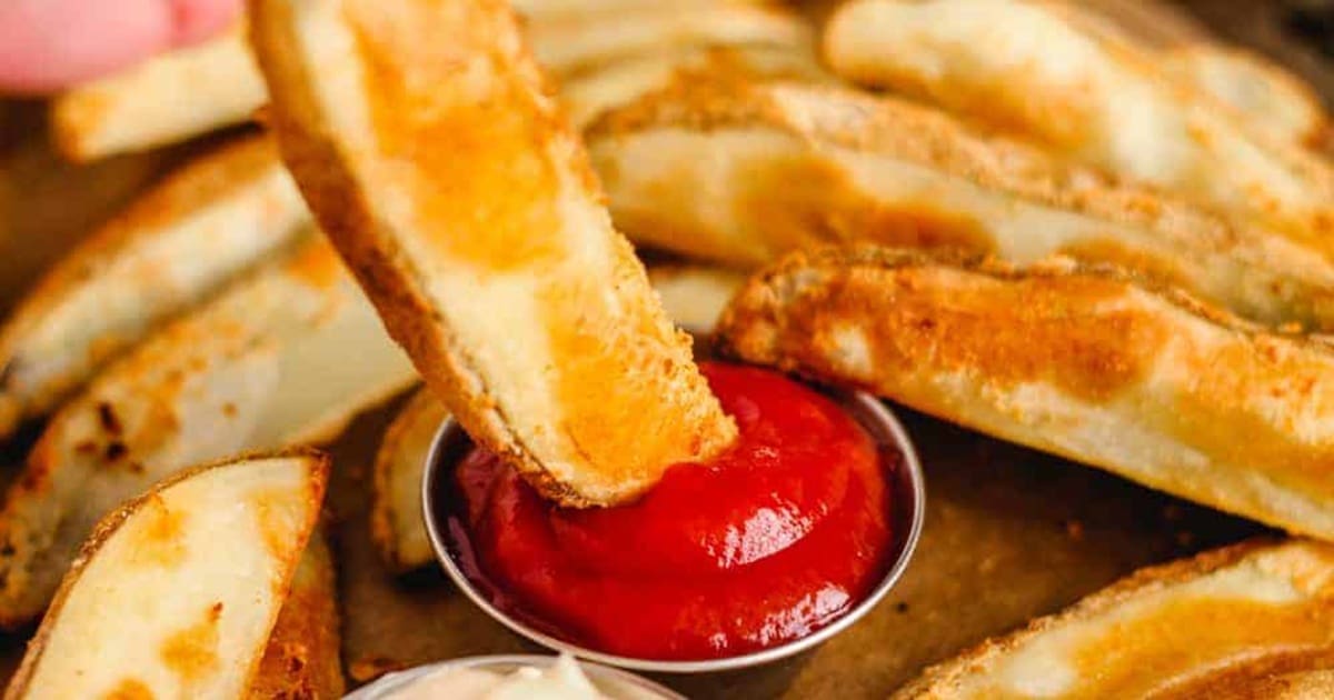 Easy Appetizers Close Up of a Potato Wedge Being Dipped into Ketchup