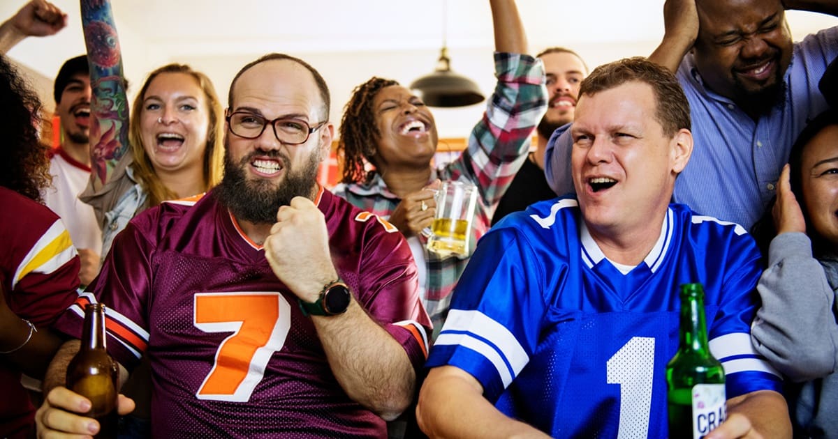 Super Bowl Air Fryer Recipes People at a Party Wearing Football Jerseys and Cheering