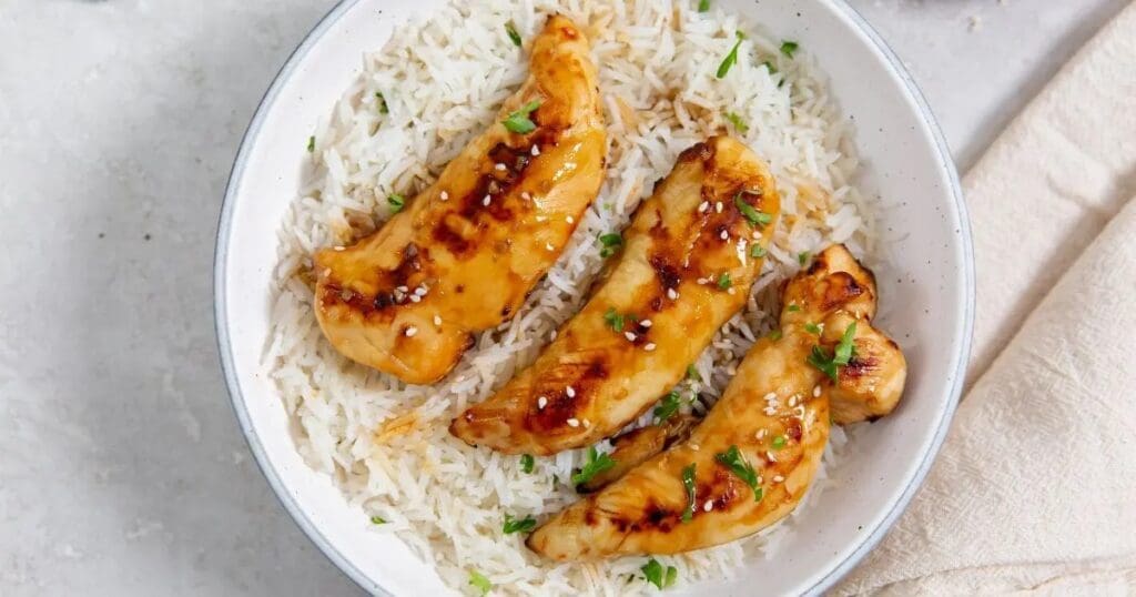 Super Bowl Air Fryer Snacks a Bowl of Rice Topped with Easy Air Fryer Teriyaki Chicken Tenders