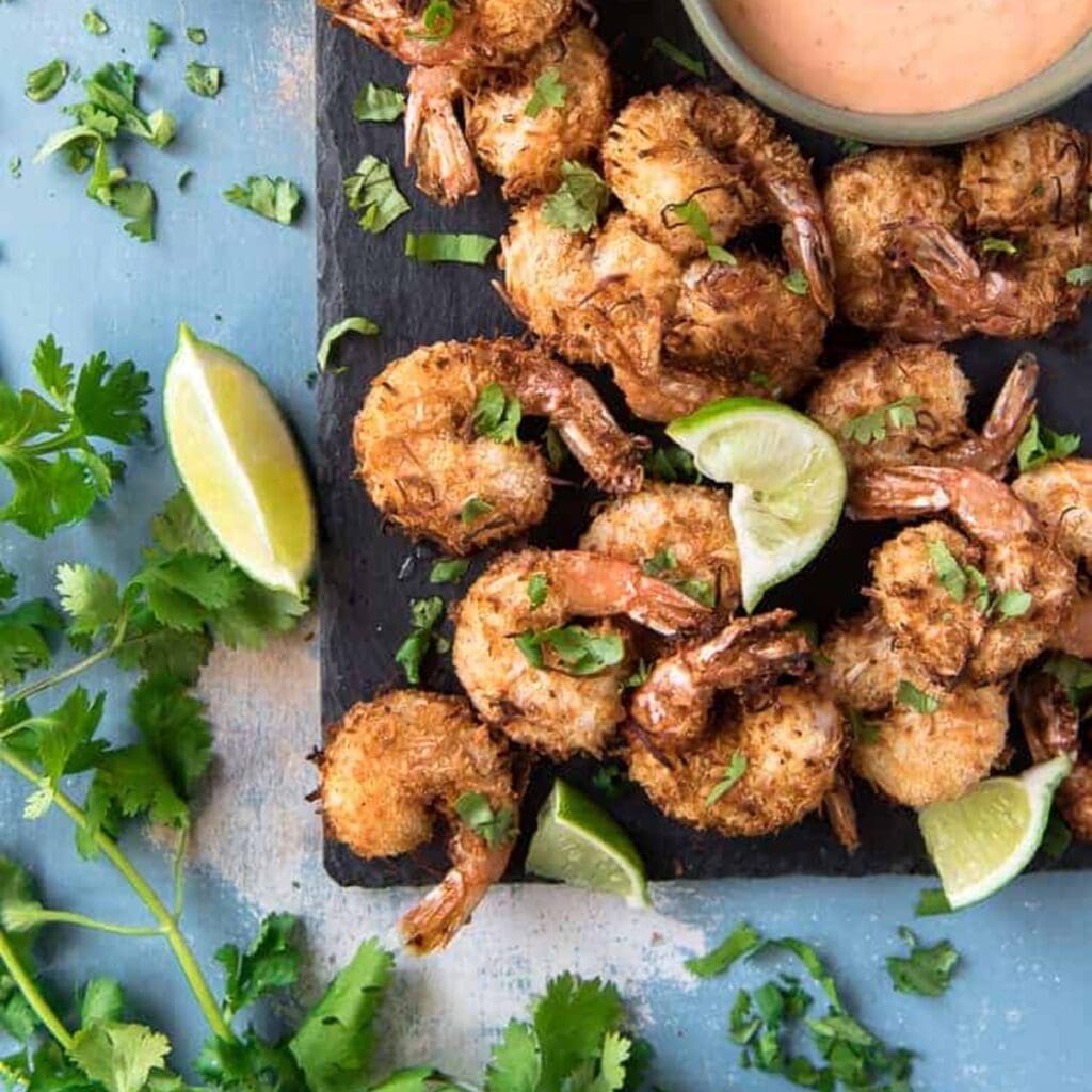 Air Fryer Recipes You Need Coconut Shrimp on a Platter with a Ramekin of Dipping Sauce
