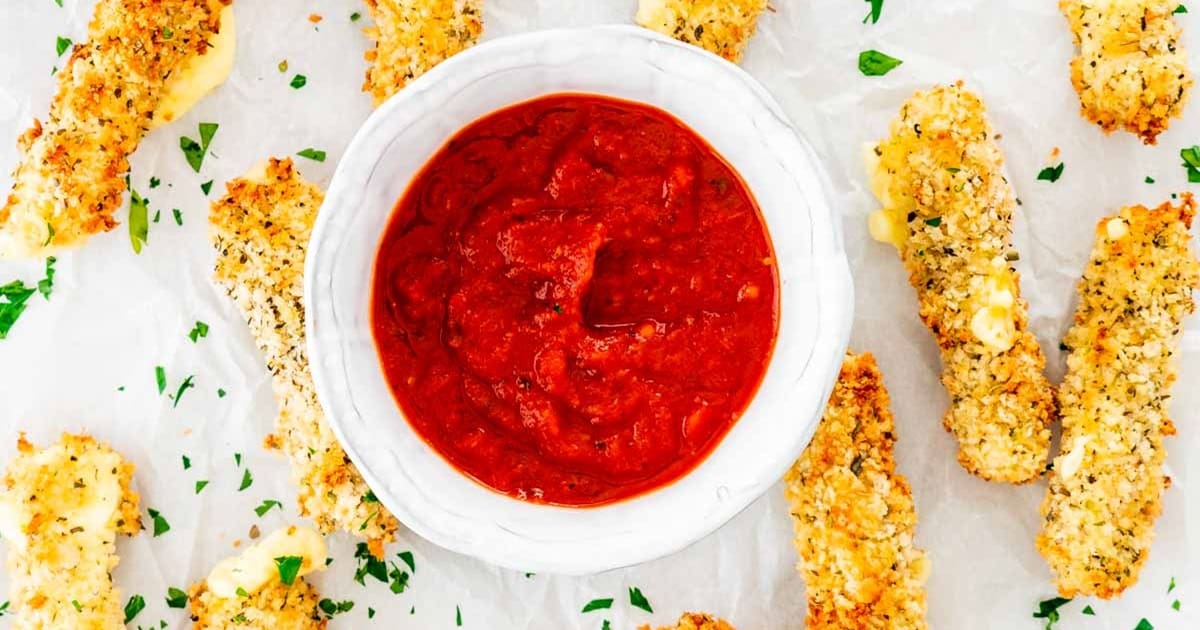Memorial Day Air Fryer Recipes Air Fryer Mozzarella Sticks Surrounding a Small Ramekin of Marinara Sauce