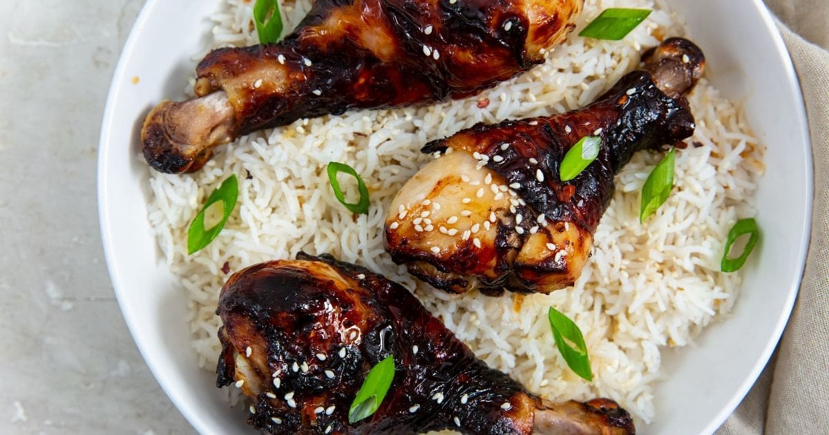 Chicken Air Fryer Recipes That Are Pure Protein Power a Bowl of Rice Topped with Crispy Air Fryer Teriyaki Chicken Legs