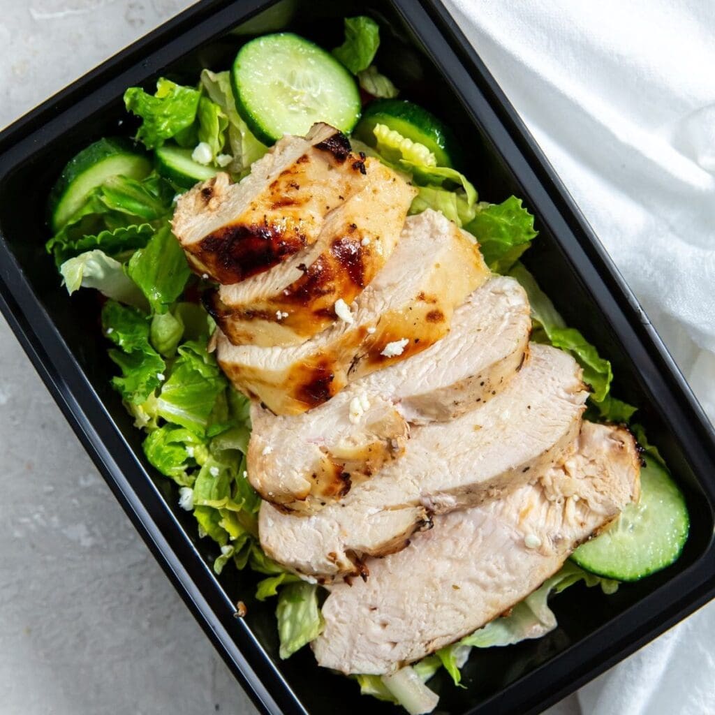 Easy Summer Air Fryer Recipes Sliced Chicken Breast on a Salad in a Meal Prep Container