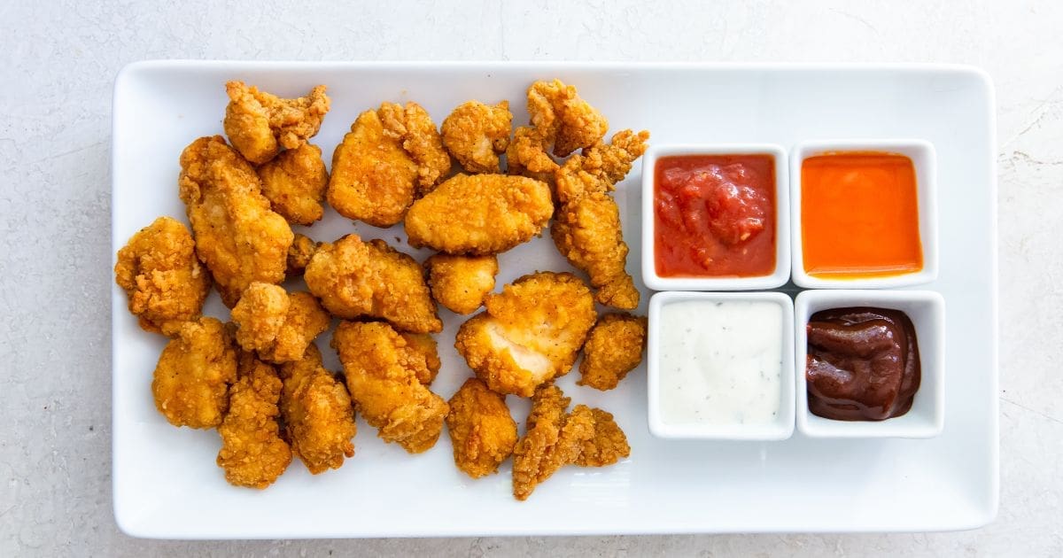 Must Make Memorial Day Recipes in your Air Fryer a Serving Platter with Tyson Any’tizers Popcorn Chicken in the Air Fryer and Four Small Ramekins of Dipping Sauces