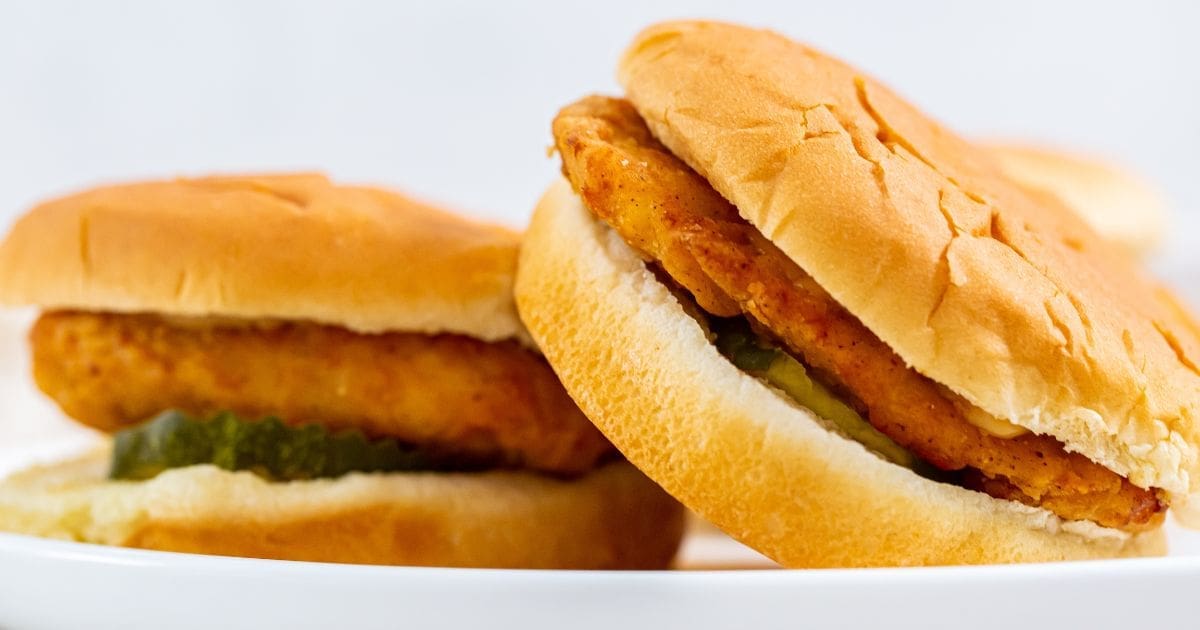 Essential Summer Air Fryer Recipes Two Chicken Sandwiches Stacked On One Another on a Plate