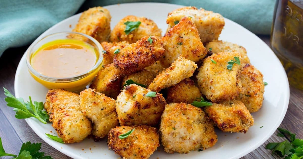 Air Fryer Parmesan Crusted Chicken Breast Recipes Close Up of Air Fryer Garlic Parmesan Chicken Nuggets on a Plate with a Small Ramekin of Dipping Sauce