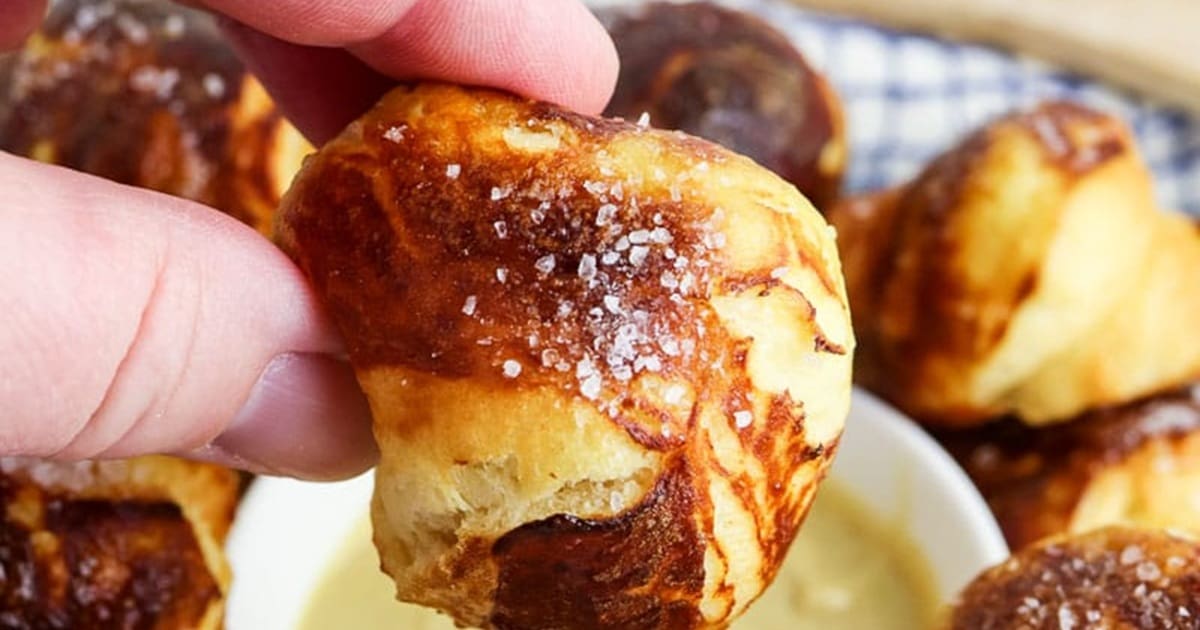 Quick Super Bowl Air Fryer Recipes Close Up of Air Fryer Pretzel Bites in a Person's Hand