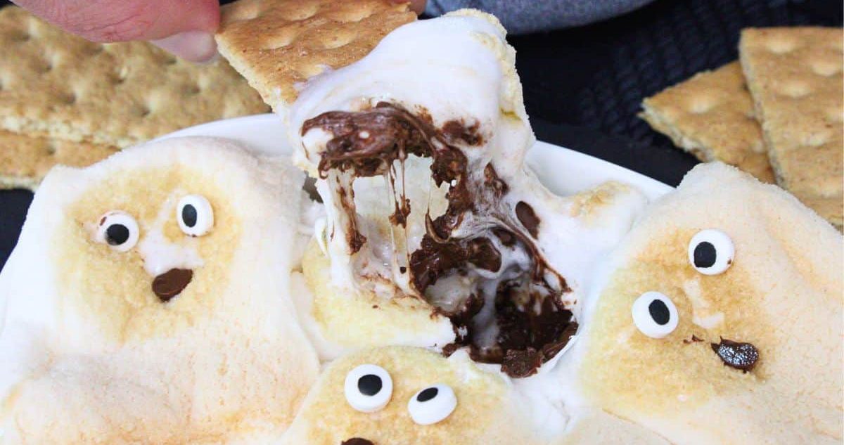 Air Fryer Halloween Recipes Close Up of a Graham Cracker Dipped into Ghost S’mores Dip