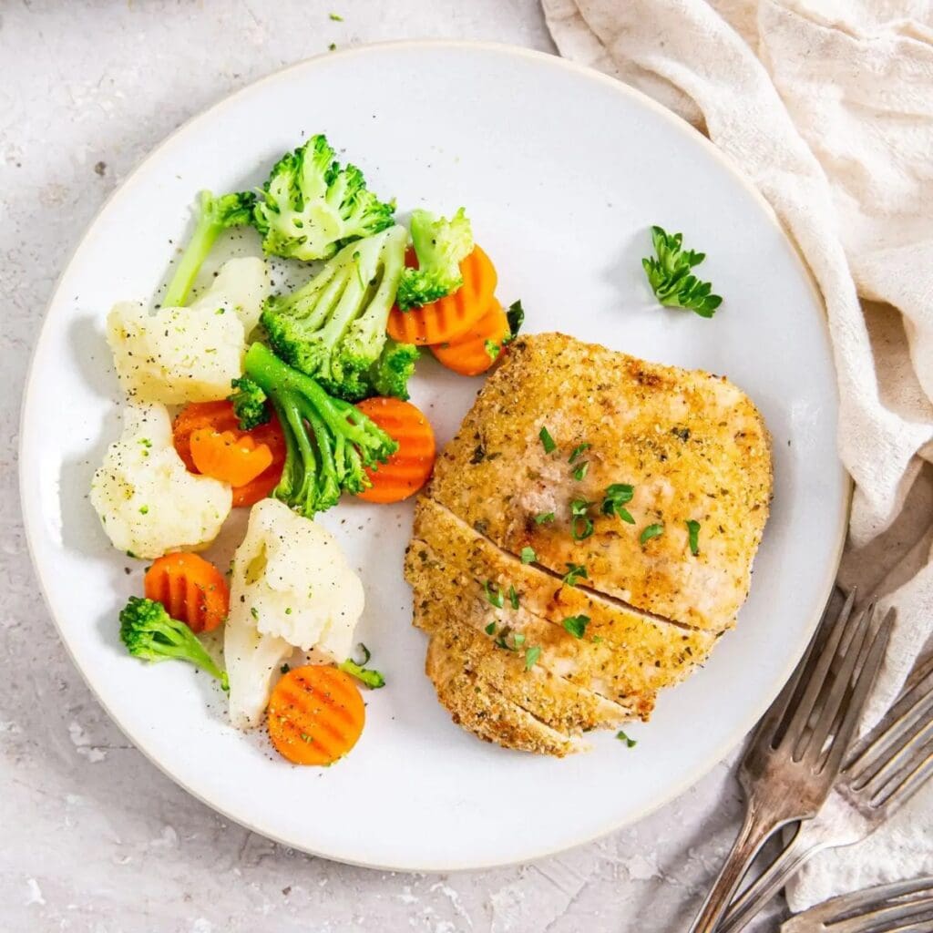 Foolproof Chicken Air Fryer Ideas Overhead View of a Plate of Chicken Cutlets with Steamed Veggies