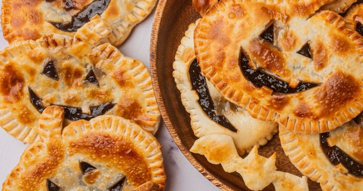 Air Fryer Halloween Recipes a Serving Platter Filled with Easy Air Fryer Jack-O-Lantern Hand Pies Recipe