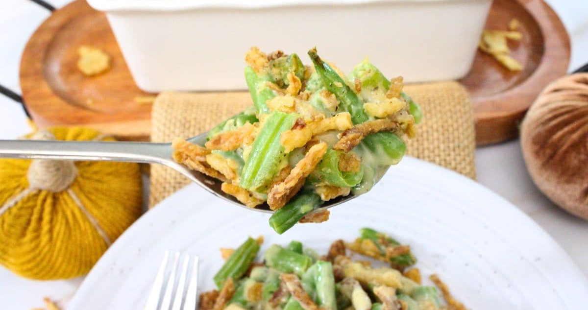 Air Fryer Thanksgiving Recipes Close Up of Air Fryer Green Bean Casserole on a Fork Above a Plate of Air Fryer Green Bean Casserole