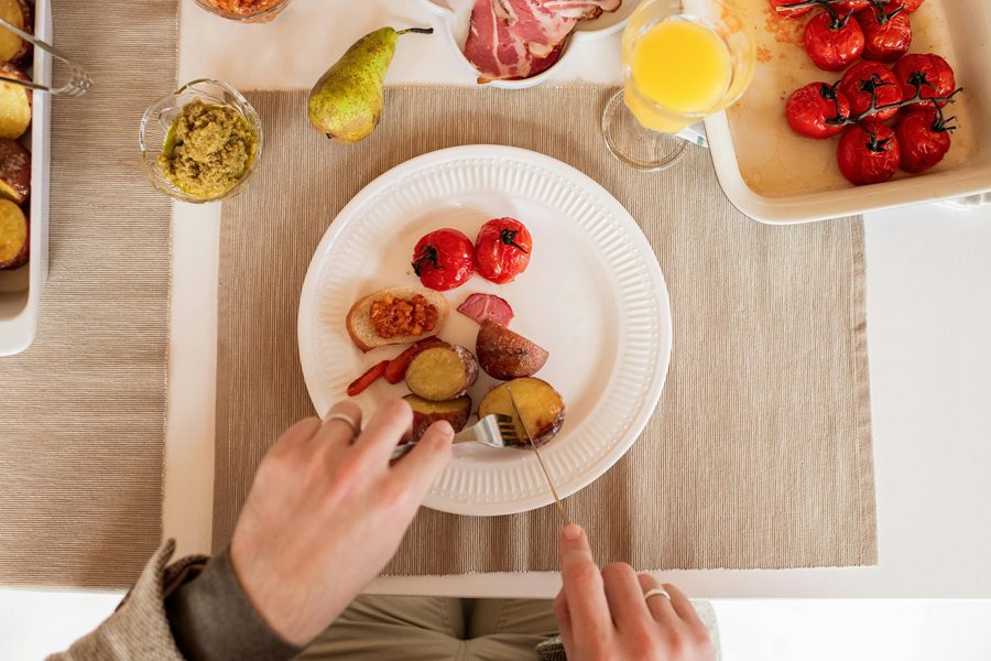 How to Make Air Fryer Red Potatoes Overhead of a Plate of Red Potatoes Being Eaten by a Person with a Fork and Knife