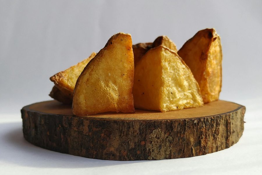 How to Make Air Fryer Red Potatoes Close Up of Red Potatoes Diced on a Small Wooden Plate