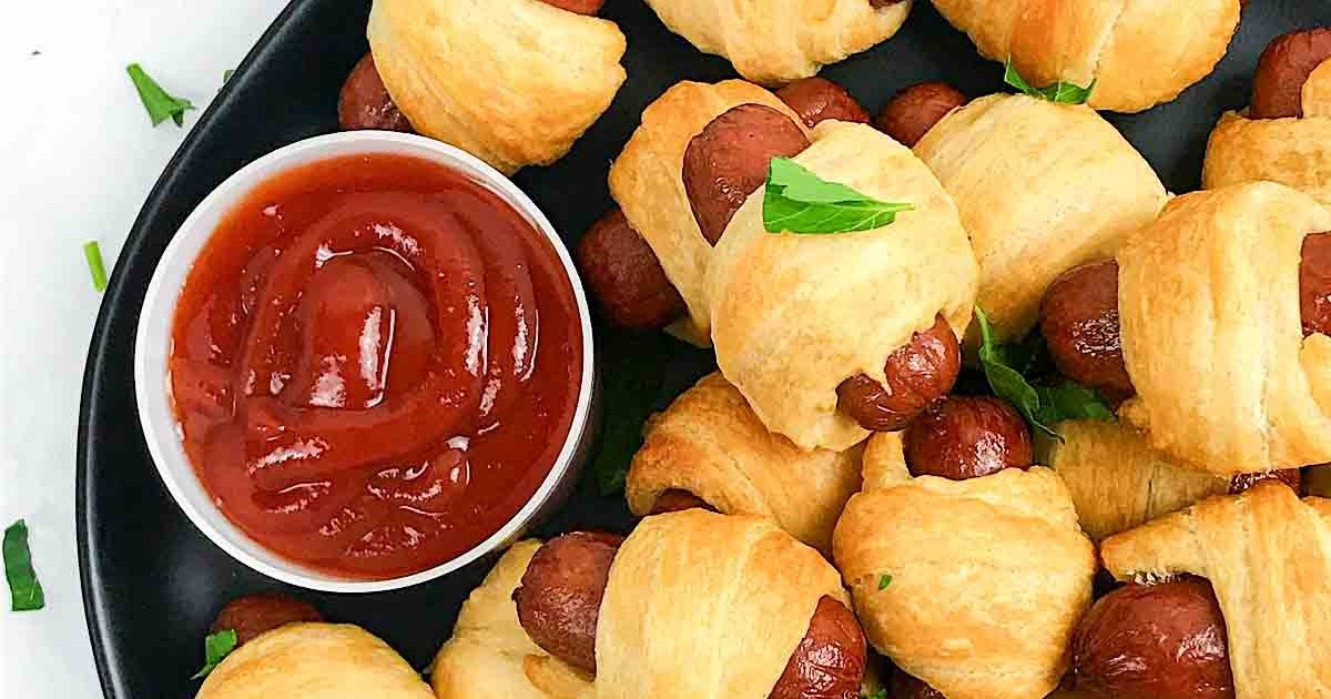 New Year's Eve Snacks Overhead of Air Fryer Pigs in a Blanket Next to a Small Dish of Dipping Sauce